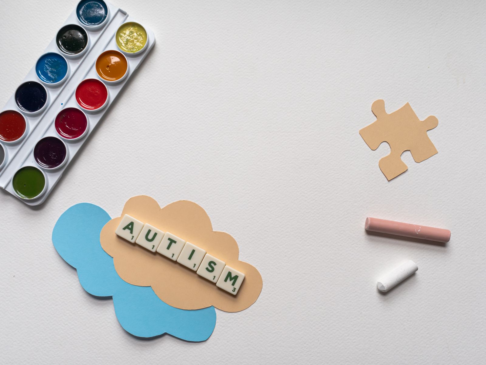 Art materials and Scrabble tiles arranged on paper — communication and learning